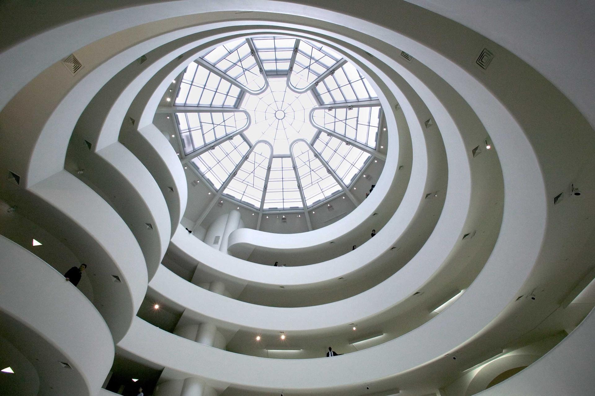 Inside of the Guggenheim Museum, Manhattan, New York City, looking up at the ceiling, with bright light coming through the skylight around the spiral staircase.